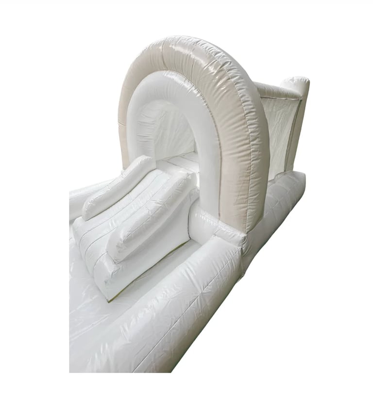 White inflatable bounce house with curved archway and slide on white background
