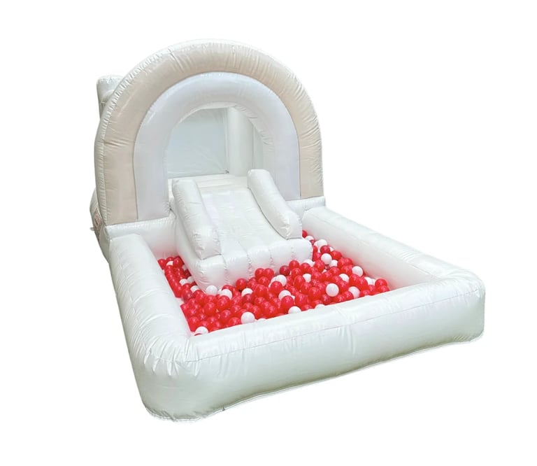 White inflatable childrens ball pit with red and white balls and a slide entrance