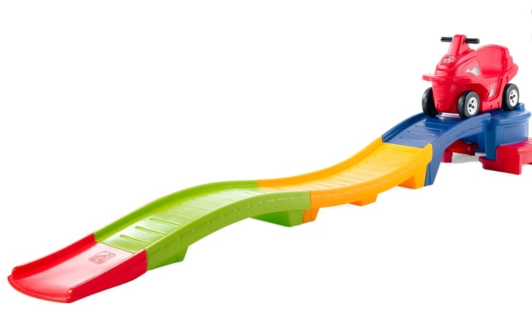Red toy truck on colorful wavy ramp track with launcher base